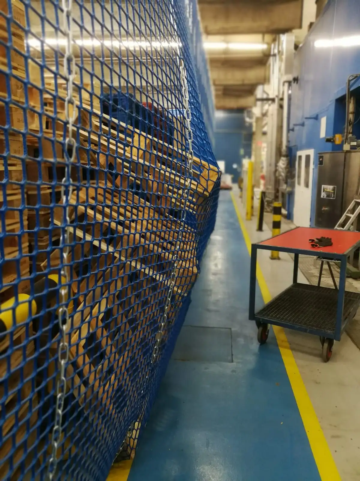 Omgevallen pallets die door een veiligheidsnet worden tegengehouden