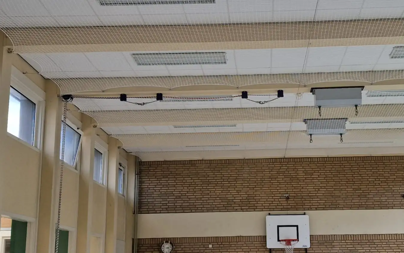 Plafondnet boven een basketbalbord in een gymzaal