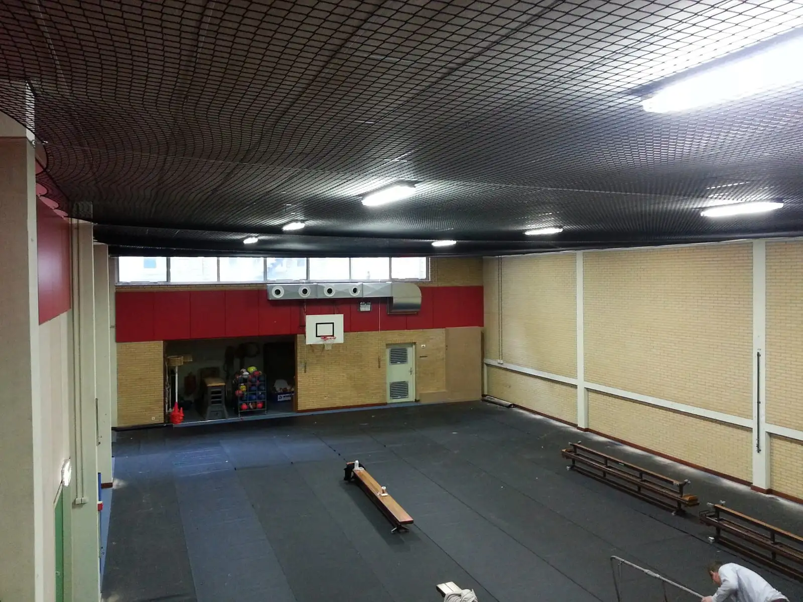 Zwart net dat het plafond van een sporthal beschermt