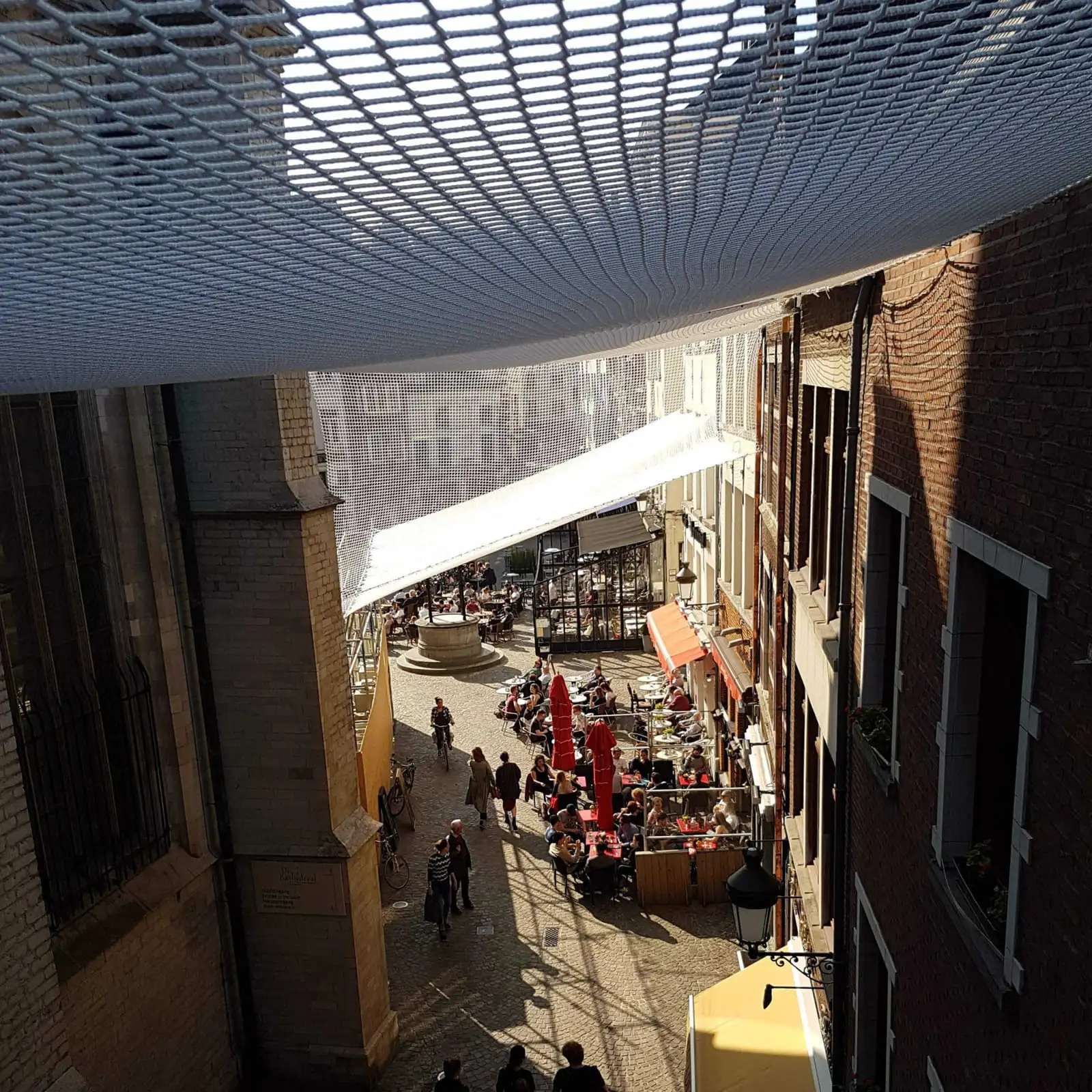 Veiligheidsnet boven een atrium met bezoekers